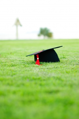 Graduation hat in a grassy field